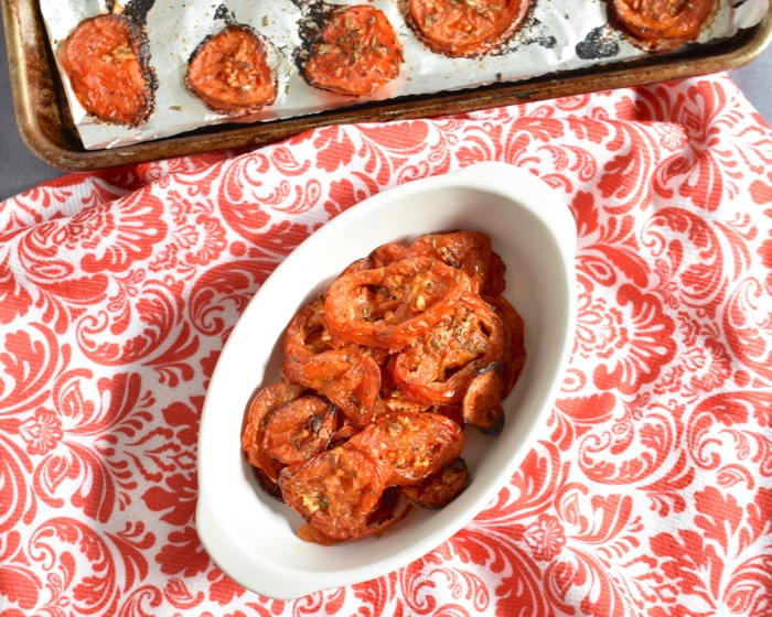 rosemary garlic oven-roasted tomatoes oven roasted tomatoes in white ramekin on red and white paisley tablecloth