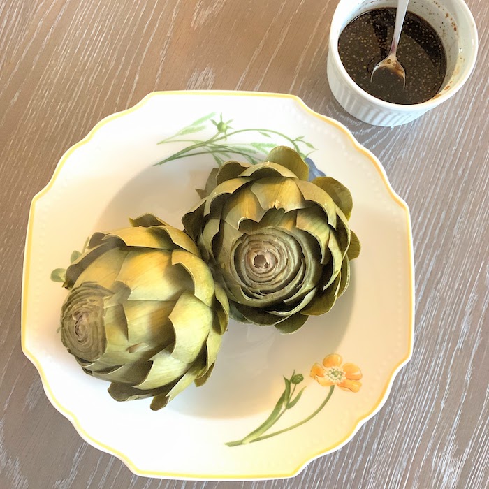 Steamed artichokes are served with a tangy vinaigrette for an irresistible appetizer or side dish. Get the gluten-free and vegan recipe via JessicaLevinson.com #ArtichokesRecipe #InstantPotArtichokes Artichokes Vinaigrette appetizer or side dish