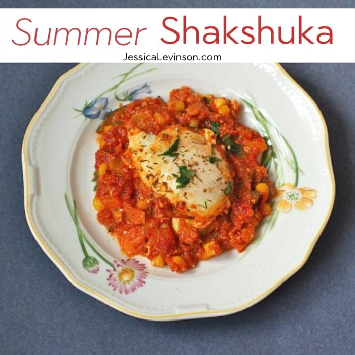 Summer Shakshuka | This summery twist on the classic Israeli breakfast recipe is an easy one-skillet dish of sautéed bell peppers, summer squash, corn, onions, and garlic in a Mediterranean-spiced tomato sauce with poached eggs and feta cheese. Get the gluten-free, vegetarian recipe via JessicaLevinson.com #EasySummerRecipes #ShakshukaRecipe. Summer Shakshuka Recipe Square with Text