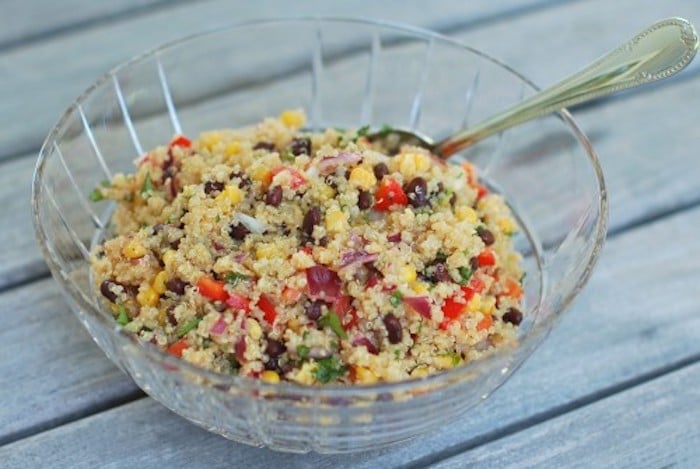 Corn and Black Bean Quinoa Salad | Corn and black beans join quinoa in a light, summery salad that's great as a side dish or for lunch on it's own. Perfect for barbecue season and Cinco de Mayo celebrations. Get the gluten-free, vegetarian, and vegan-friendly recipe via JessicaLevinson.com #healthyquinoasalad #summerquinoasalad Corn and Black Bean Quinoa Salad in Glass Bowl