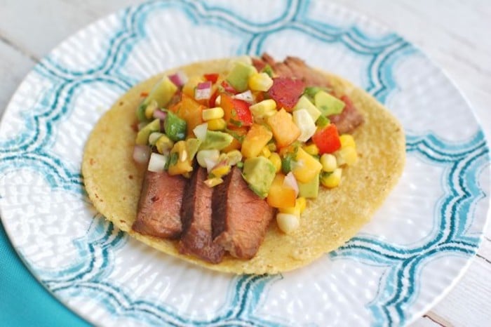 Enjoy the nutrition and health benefits of lean beef with this juicy soy-marinated flank steak taco topped with a colorful and nutritious nectarine corn salsa brimming with the flavors of summer @jlevinsonRD #sponsored #summertacos #steaktacosrecipe Soy-Marinated Steak Tacos on Plate with Salsa