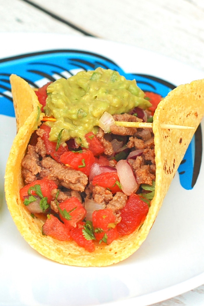The whole family can participate in taco night with these smoky chipotle beef tacos topped with cooling guacamole and watermelon salsa! Get the gluten-free, dairy-free, and family-friendly recipe @jlevinsonrd. #healthybeeftacos #easybeeftacorecipe Chipotle Beef Tacos Topped with Guacamole