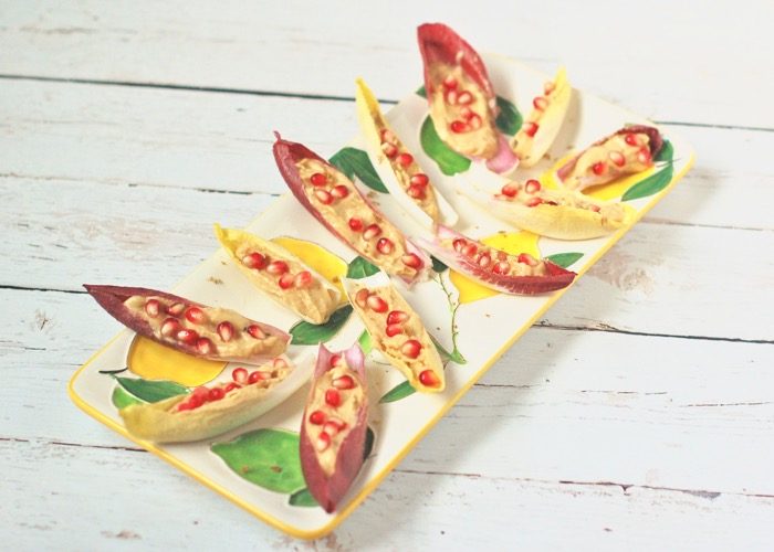 Wow your guests with zesty, creamy lemon hummus endive boats topped with sweet and juicy pomegranate seeds. A pretty, flavorful, nutritious and delicious appetizer perfect for a crowd. lemon hummus endive boats with pomegranate seeds hors d'oeuvres