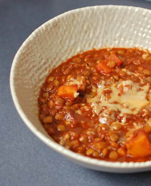 Warm up with a bowl of hearty lentil chili that's packed with vegetables and brimming with flavor and nutrition. Enjoy topped with shredded cheese or mashed avocado. Get the vegan and gluten-free recipe via JessicaLevinson.com #VeganChili #VegetarianChiliRecipe Bowl of Hearty Vegetable Lentil Chili