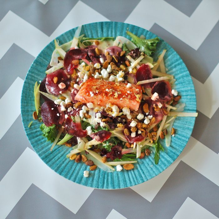 This Salmon Waldorf Salad combines mixed greens, ruby red beets, crisp fennel and green apple, crunchy pistachios, creamy goat cheese, and heart-healthy salmon with a citrus yogurt vinaigrette. A nutritious and delicious twist on the classic Waldorf salad. Get the gluten-free recipe via JessicaLevinson.com #waldorfsalad #healthysalads #salmonsalad Salmon Waldorf Salad Overhead