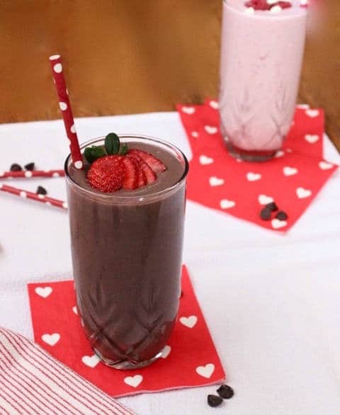 Dark chocolate, creamy greek yogurt, and sweet strawberries are the perfect combination in this frosty, high protein and heart-healthy Valentine's Day Dark Chocolate Strawberry Smoothie! Get the gluten-free and vegetarian recipe via JessicaLevinson.com | #strawberrysmoothierecipe #chocolatesmoothie #proteinsmoothie Dark Chocolate Strawberry Smoothie in Cups