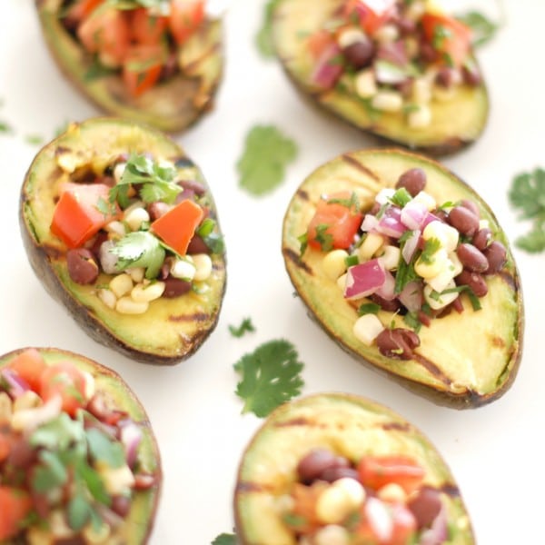 Grilled avocados are stuffed with a light and fresh mixture of corn, black beans, and tomatoes in this elegant yet simple appetizer, side dish, or entrée. Get the gluten-free and vegan recipe via JessicaLevinson.com #GrilledAvocados #StuffedAvocados Grilled Avocados Filled with Corn Black Bean Salsa