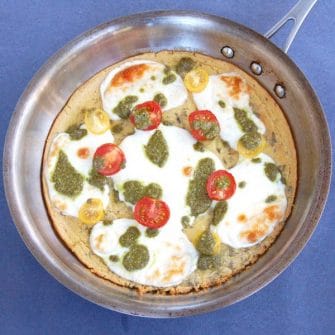 Farinata with Tomato, Mozzarella, & Pesto Drizzle | A chickpea flour crust is topped with tomatoes, mozzarella, and basil pesto in this easy, gluten-free, vegetarian twist on traditional Italian farinata. Recipe @jlevinsonrd.