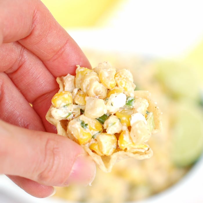 Enjoy a tortilla chip filled with street corn salad Tortilla Chip Mexican Corn Salad