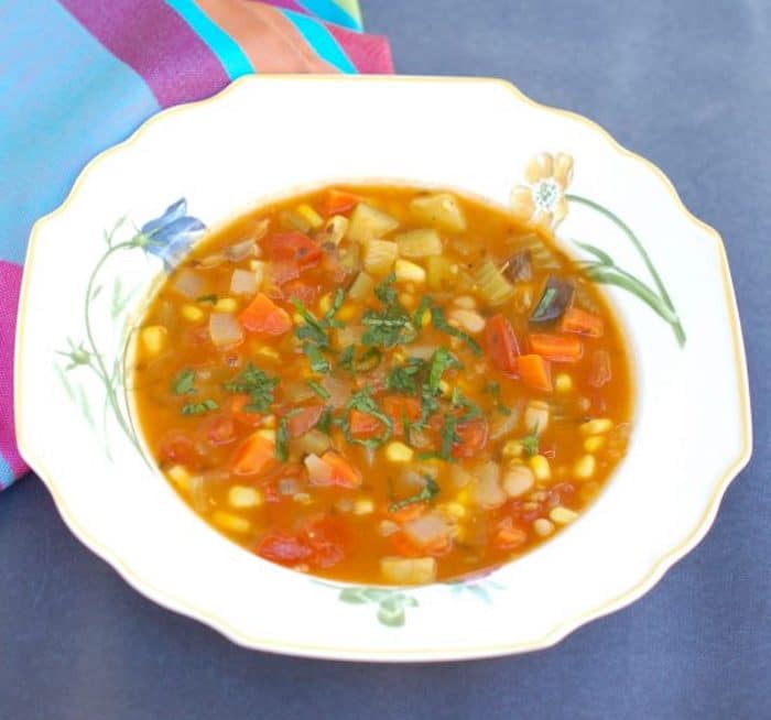 Use the last of summer’s bounty of zucchini, tomatoes, and corn to make this hearty vegetable soup brimming with flavor and nutrition. Vegan, Vegetarian, Gluten-Free, and Dairy-Free. Recipe @jlevinsonrd #summersoup #summervegetables Late Summer Vegetable Soup in Bowl