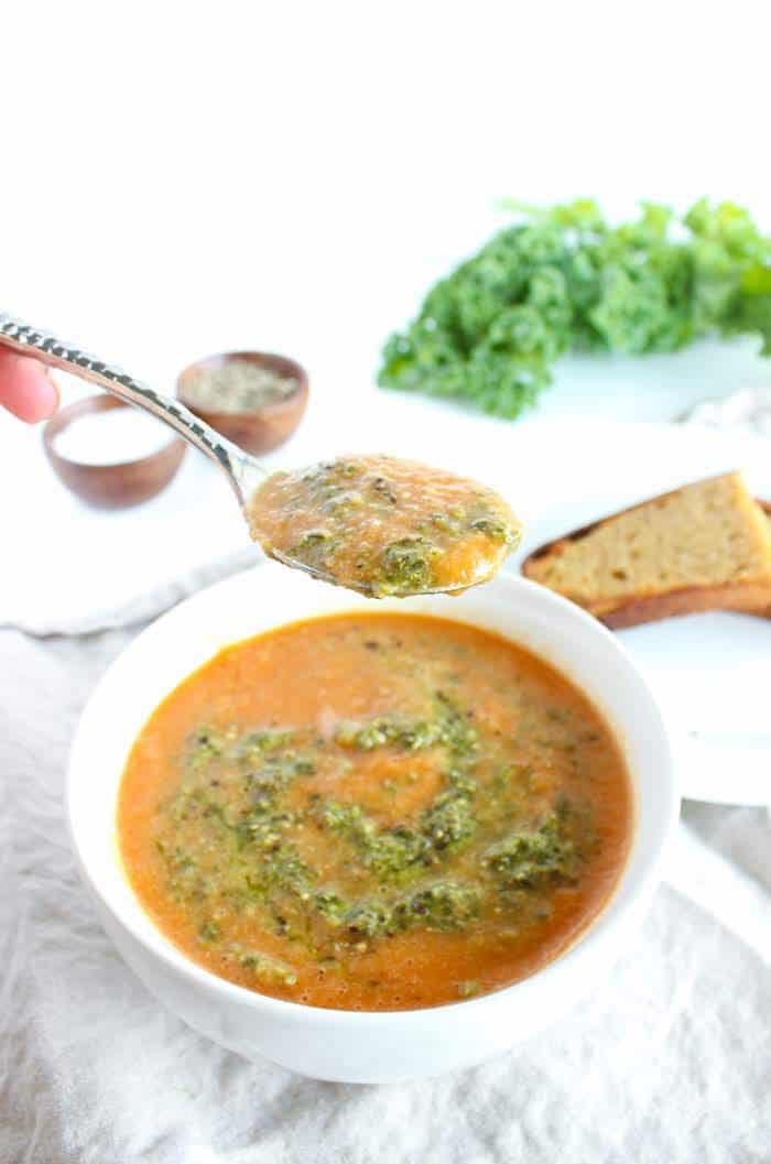 Warm up this fall and winter with a bowl of tomato white bean soup topped off with a dollop of kale pesto. Gluten free, vegetarian, and vegan-friendly. Recipe via JessicaLevison.com #TomatoSoupRecipe #VegetarianSoup Tomato White Bean Soup with Spoon