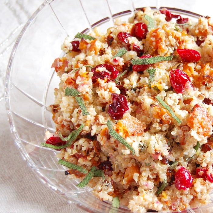 Add a burst of color and flavor to the holiday table with this nutritious and delicious Roasted Butternut Squash and Cranberry Quinoa Salad. Get the vegan and gluten-free recipe at JessicaLevinson.com close up of roasted butternut squash and cranberry quinoa salad topped with sage and pecans
