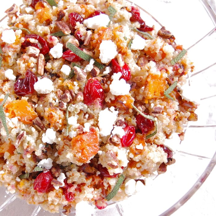 Add a burst of color and flavor to the holiday table with this nutritious and delicious Roasted Butternut Squash and Cranberry Quinoa Salad. Get the gluten-free recipe at JessicaLevinson.com roasted butternut squash and cranberry quinoa salad topped with goat cheese and pecans for a protein boost