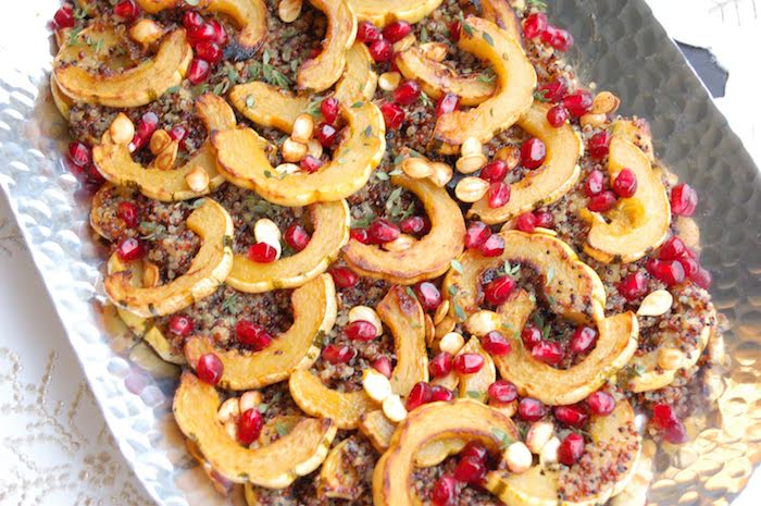 Maple-roasted delicata squash tops cider-infused quinoa and is garnished with thyme and pomegranate seeds in this easy, yet elegant side dish that's perfect for the holidays or any day of the week. Recipe via JessicaLevinson.com #VeganRecipe #QuinoaSaladRecipe #FallSideDish Maple-Roasted Delicata Squash Quinoa Salad in Silver Dish