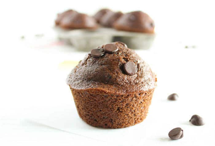 Delicious whole grain double chocolate muffins taste sinful but aren’t! A great make-ahead breakfast treat or healthier dessert. Get this vegetarian and nut-free recipe at JessicaLevinson.com | #WholeGrainMuffins #ChocolateMuffins #BreakfastMuffins Close up of Whole Grain Double Chocolate Muffins
