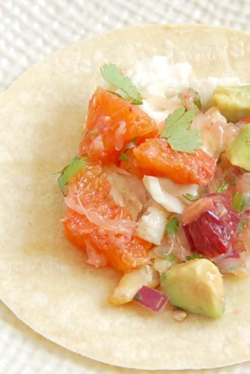 Fish Tacos with Citrus Salsa are a quick and easy, flavor-packed dinner the whole family will enjoy. Get the gluten-free, dairy-free recipe via JessicaLevinson.com #fishtacos #citrusrecipe #healthytacos Close Up of Fish Tacos with Citrus Salsa