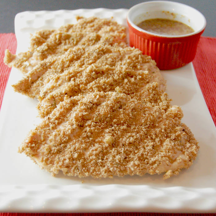 Satisfy your kids' cravings for chicken fingers in a healthier way with this crispy whole grain baked panko crusted chicken. Serve with a simple honey mustard sauce for a dinner the whole family will love. via JessicaLevinson.com | #dairyfreechicken #nutfreebakedchicken #healthierbakedchicken Panko Crusted Chicken with Honey Mustard Sauce