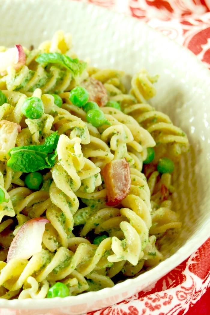 Whole grain pasta is tossed with peas, roasted radishes, and a nut-free mint and radish greens pesto in this light and delicious spring pasta dish. Get this vegetarian recipe via JessicaLevinson.com #SpringPastaSalad #VegetarianPasta #PestoPastaSalad Close Up Radish Greens Pesto Pasta Salad