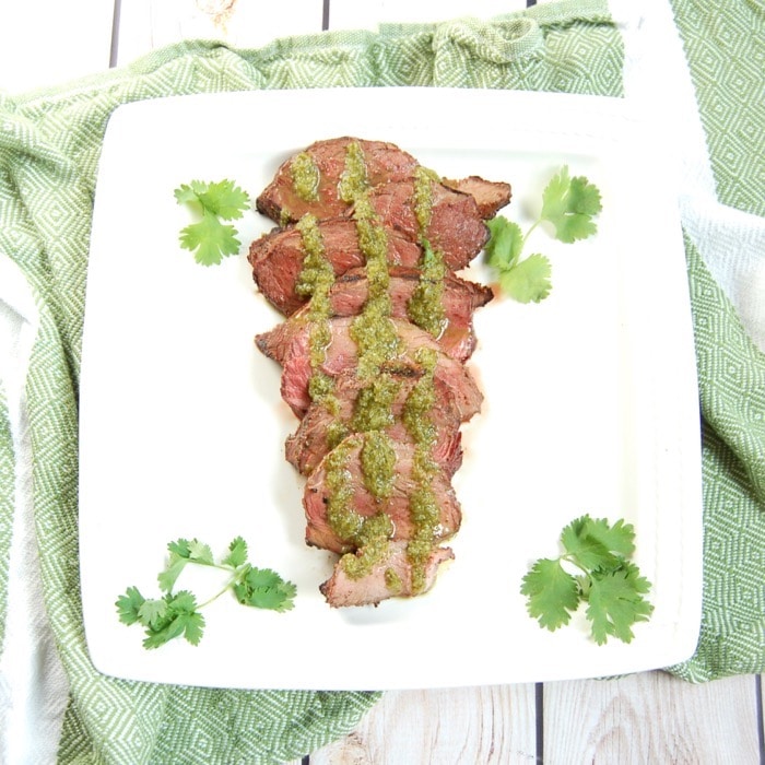 Perfectly grilled Cilantro Lime Steak is easy to make and a delicious entrée to serve guests at your summer barbecue. Recipe via JessicaLevinson.com | #GrilledSteakRecipe #SteakMarinadeRecipe Grilled Cilantro Lime Steak on Plate with Marinade