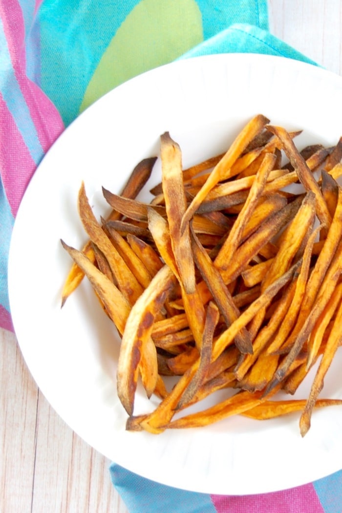 Crispy baked sweet potato fries are easy to make, kid-friendly, and delicious. The perfect side dish for any weeknight family dinner! Get the recipe at JessicaLevinson.com #HealthySweetPotatoFries #BakedSweetPotatoFriesRecipe Crispy Baked Sweet Potato Fries On Plate Overhead