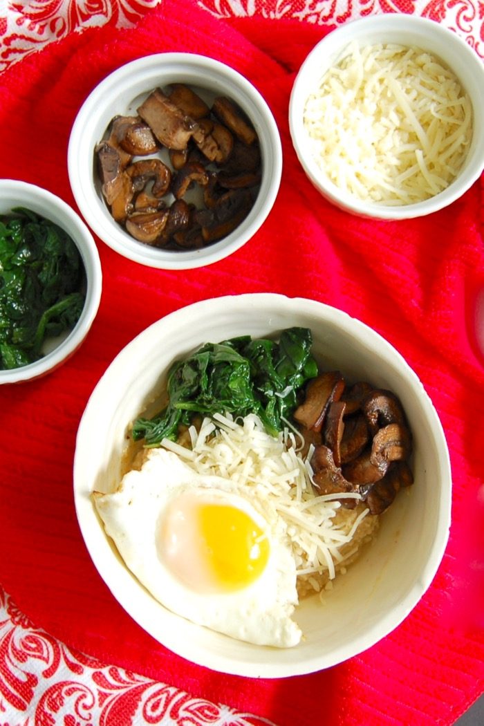 Get a serving of vegetables and protein at breakfast with this umami-rich savory oatmeal breakfast bowl with spinach, mushrooms, and fried egg. Get the gluten-free, vegetarian, and vegan-friendly recipe at JessicaLevinson.com. savory oatmeal bowl with mushrooms, spinach, cheese, and fried egg