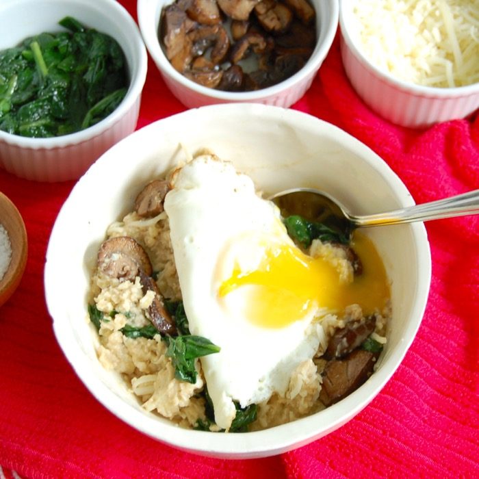 Get a serving of vegetables and protein at breakfast with this umami-rich savory oatmeal breakfast bowl with spinach, mushrooms, and fried egg. Get the gluten-free, vegetarian, and vegan-friendly recipe @ JessicaLevinson.com savory oatmeal bowl with runny fried egg