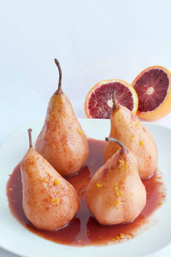 Blood Orange Poached Pears are made with only five simple ingredients, and no added sweeteners. A simple and elegant dessert for any occasion! Get the vegan and gluten-free recipe at JessicaLevinson.com | #lowsugar #winterrecipes #oranges #pears Blood Orange Poached Pears on Plate