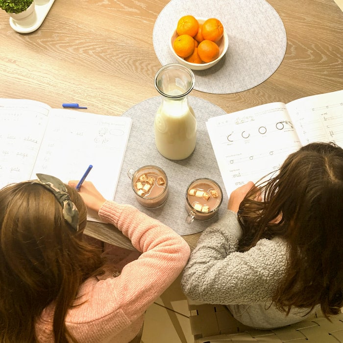 Hot cocoa and homework overhead image of children doing homework with hot chocolate